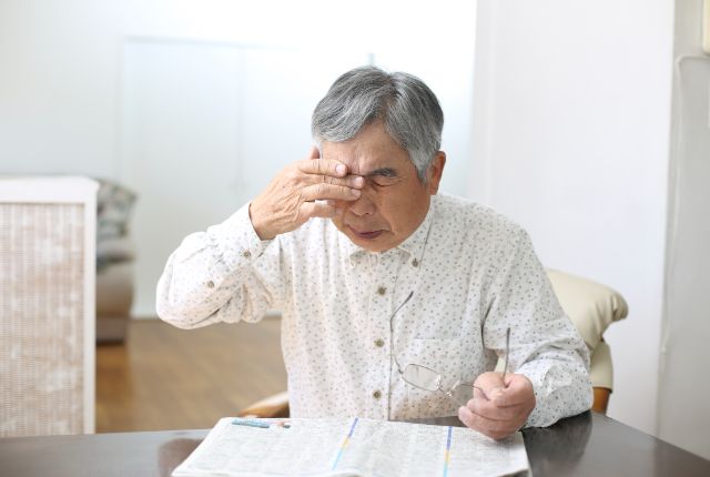 目をこするシニア男性